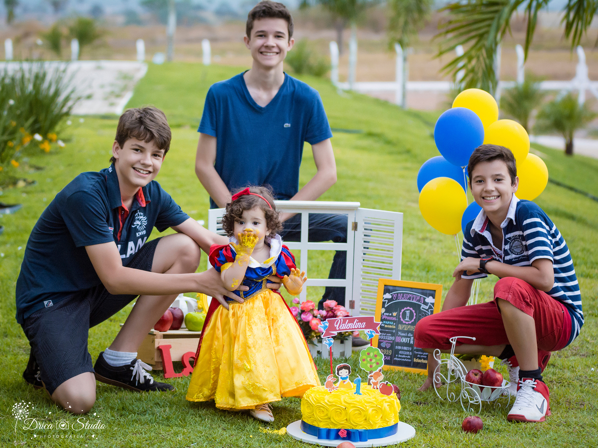  Smash the Cake- Branca de Neve- sorrindo- com bolo-com os irmãos -Xinguara- Pará- ensaio infantil- ensaio externo- ensaio de família- contos de fada- grama verde- amarelo- Fotógrafa- Drica Studio- Fotografia de família- fotografa em Xinguara- cenário.