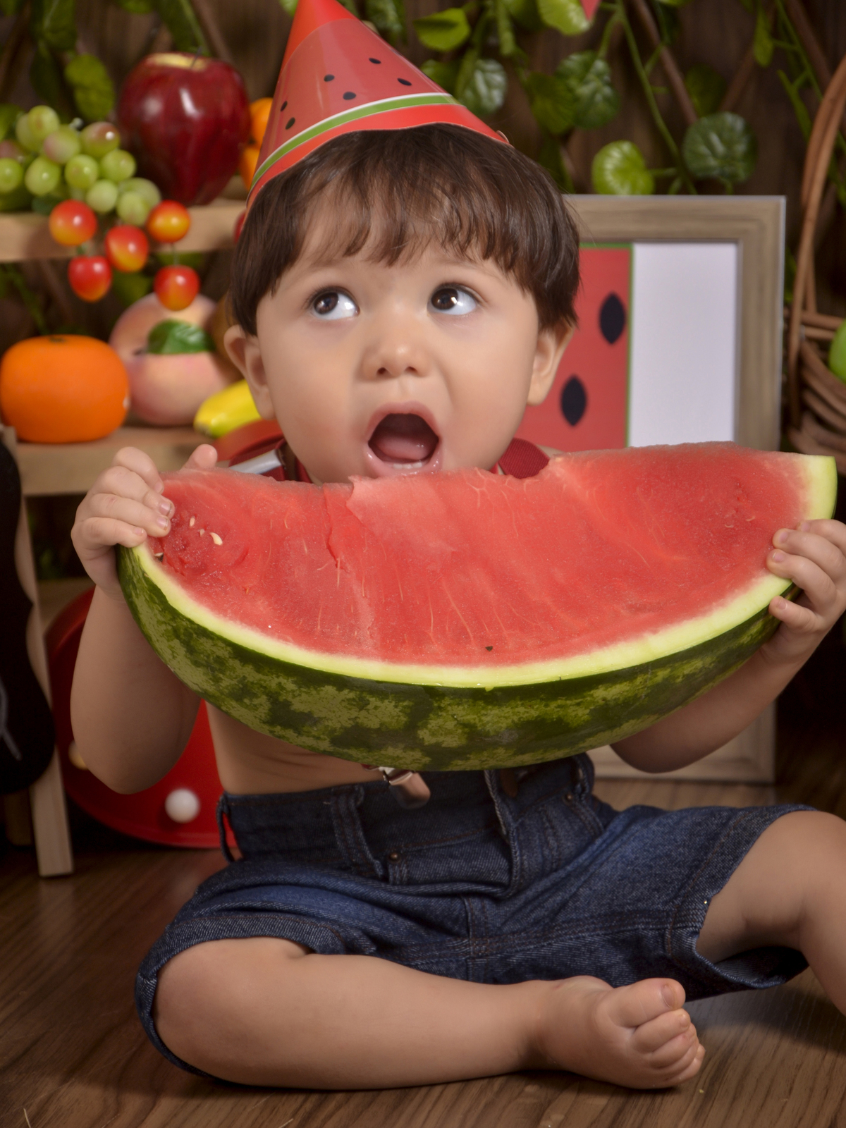 mordendo a melancia- Smash the Fruit-fruta-melancia-suspensório vermelho -ensaio infantil-Cenário colorido-one-crianças-book-acompanhamento mensal-Kids-foto em estúdio-Newborn-gravata-gestante-Fotografa de família-Drica Studio-fotografa  em Xinguara-Pará.