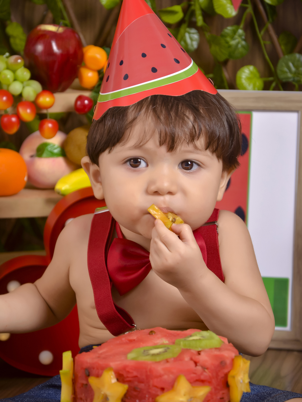 comendo carambola- Smash the Fruit-fruta-melancia-suspensório vermelho-gravata-ensaio infantil-Cenário colorido-one-crianças-book-acompanhamento mensal-Kids-foto em estúdio-Newborn-gestante-Fotografa de família-Drica Studio-fotografa  em Xinguara-Pará.