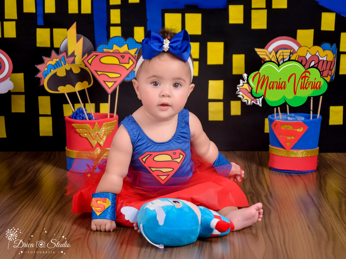 Super bebê-ensaio infantil-foto-super herói supergirl-acompanhamento mensal do Eduardo cenário temático-book- mini- sessão Kids-Drica Studio Fotografias-Xinguara Pará-tule vermelho-laço azul simbolo s no braço e peito.