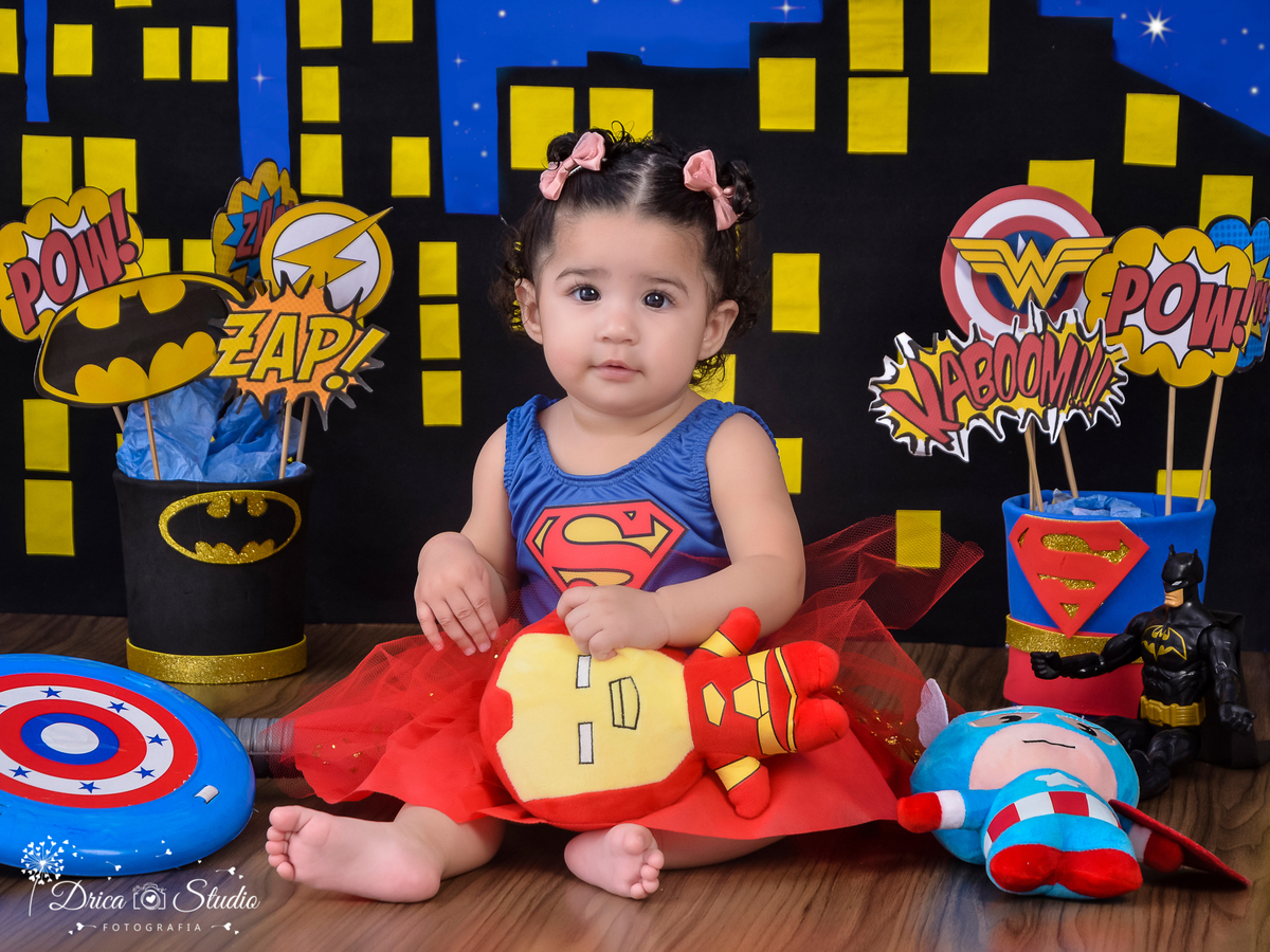 Super bebê linda-ensaio infantil-foto-super herói supergirl-acompanhamento mensal do Eduardo cenário temático-book- mini- sessão Kids-Drica Studio Fotografias-Xinguara Pará-tule vermelho-laço azul simbolo s no braço e peito.