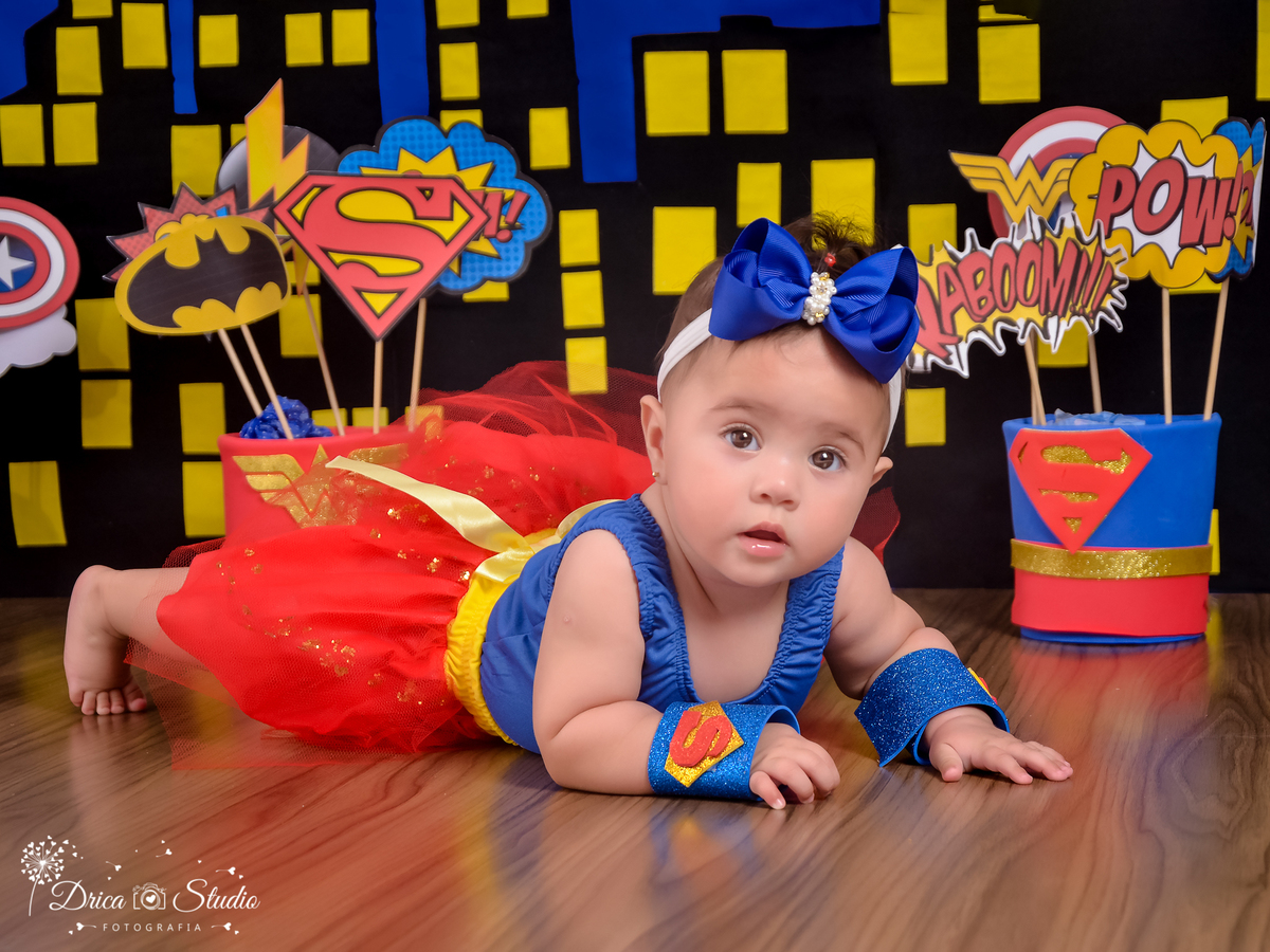 Super bebê-ensaio infantil-foto-super herói supergirl-acompanhamento mensal do Eduardo cenário temático-book- mini- sessão Kids-Drica Studio Fotografias-Xinguara Pará-tule vermelho-laço azul simbolo s no braço.