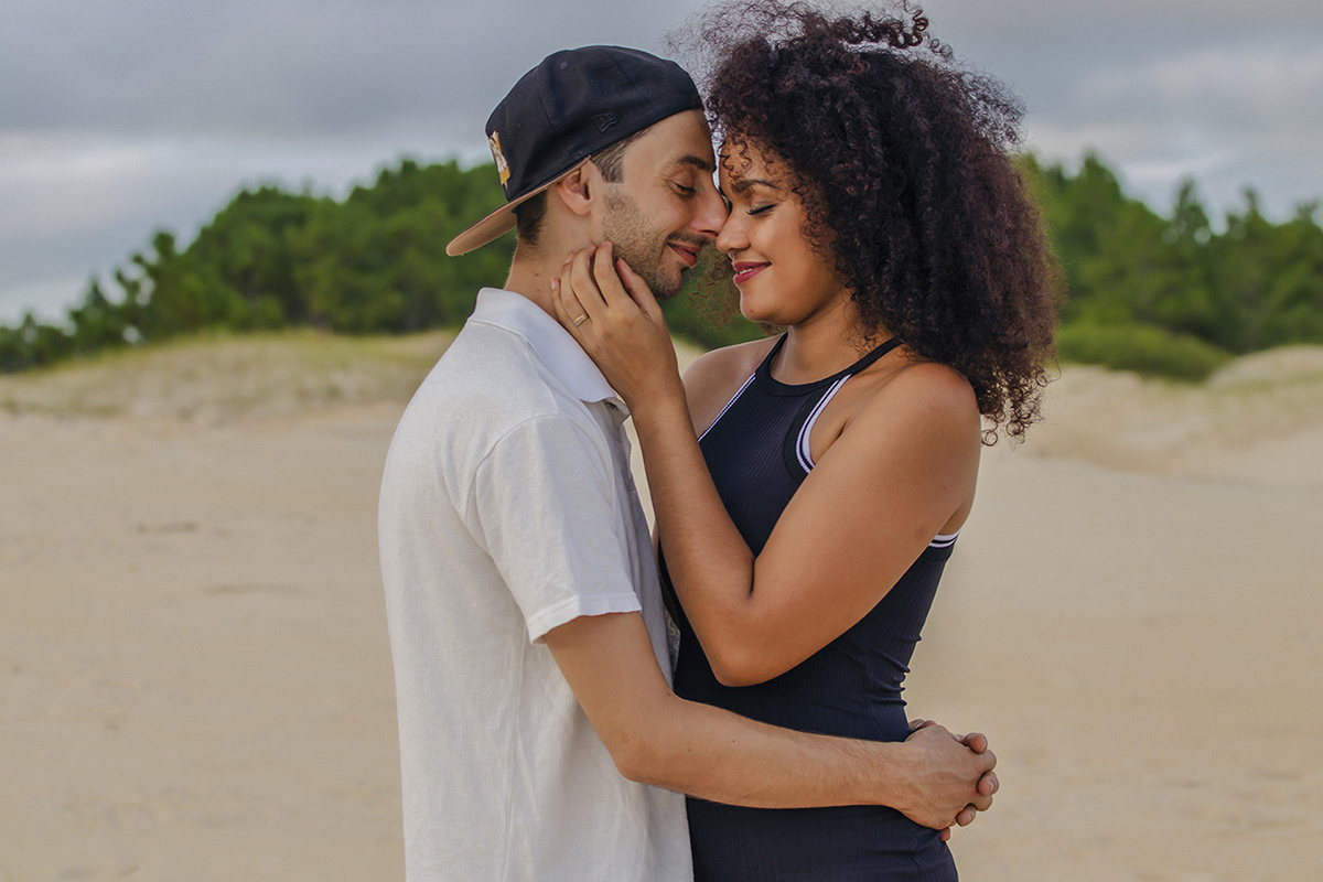 casal abraçado nas dunas de olhos fechados