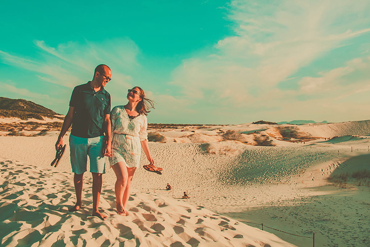casal de maos dadas nas dunas