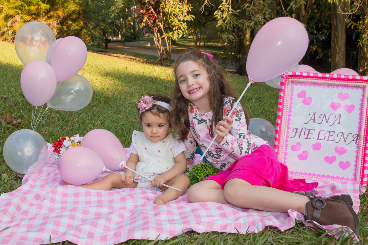 MENINAS sentadas em uma toalha xadrez cor de rosa no click da FOTÓGRAFA de ENSAIO SMASH THE FRUIT em SÃO PAULO, SP sorridentes em uma imagem colorida