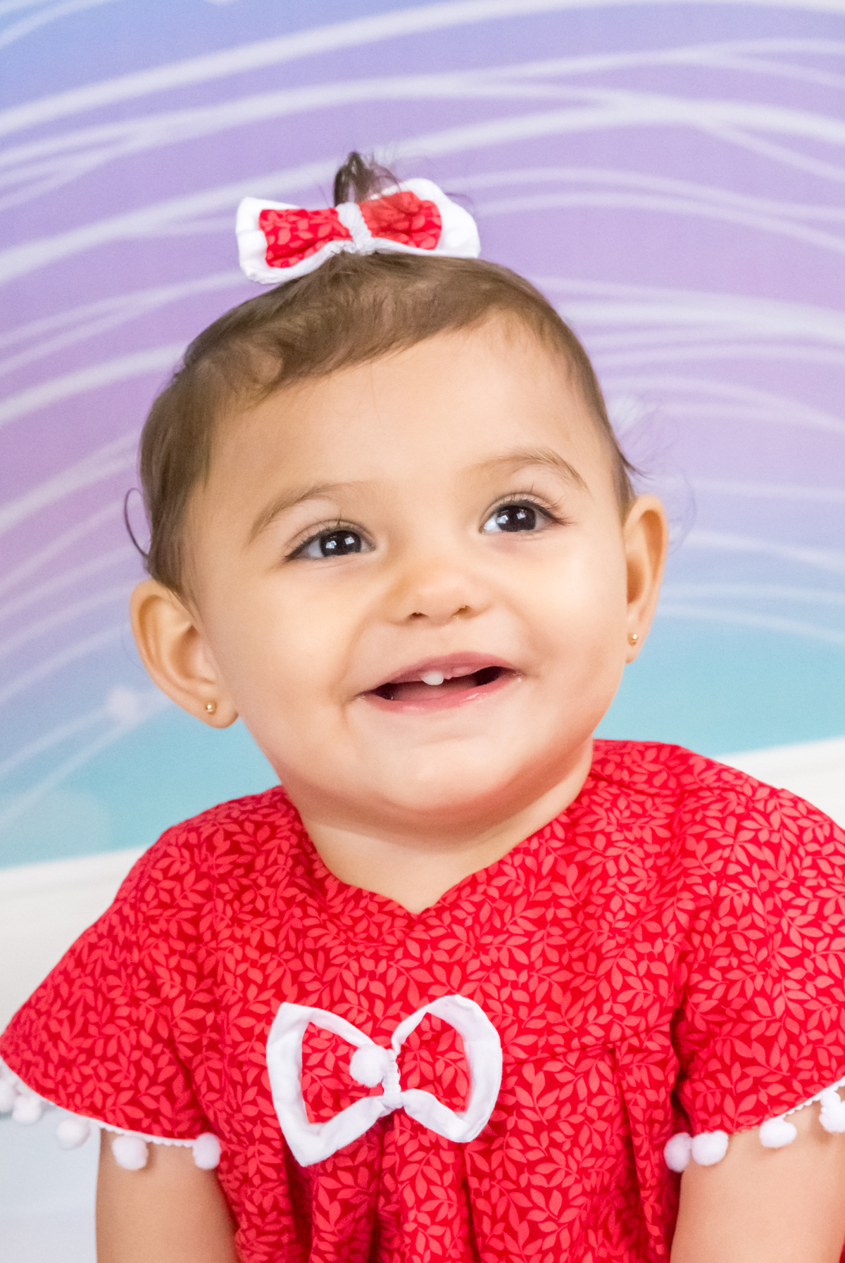 MENINA sentada de VESTIDO VERMELHO olhando para cima  no click da FOTÓGRAFA de ENSAIO SMASH THE CAKE em SÃO PAULO, SP sorridente em uma imagem colorida
