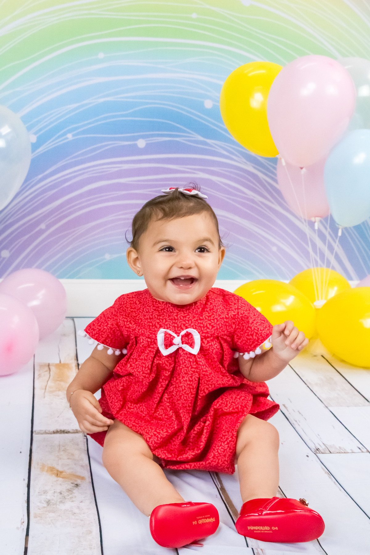 MENINA sentada de VESTIDO VERMELHO olhando para a CÂMERA no click da FOTÓGRAFA de ENSAIO SMASH THE CAKE em SÃO PAULO, SP sorridente em uma imagem colorida