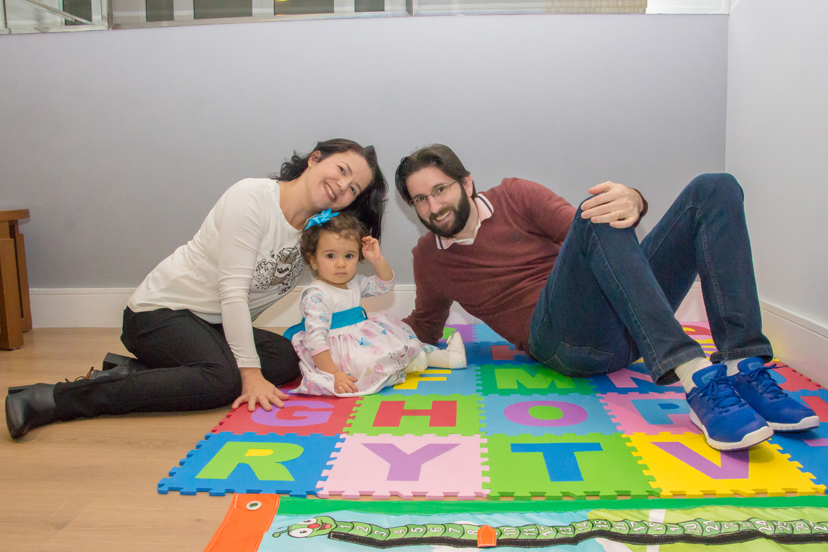 MENINA sentada com os PAIS de vestido com LAÇO AZUL em festa tema JARDIM ENCANTADO nas cores VERDE e CORES PASTÉIS no click da FOTÓGRAFA de FESTA INFANTIL em SÃO PAULO, SP em uma imagem colorida