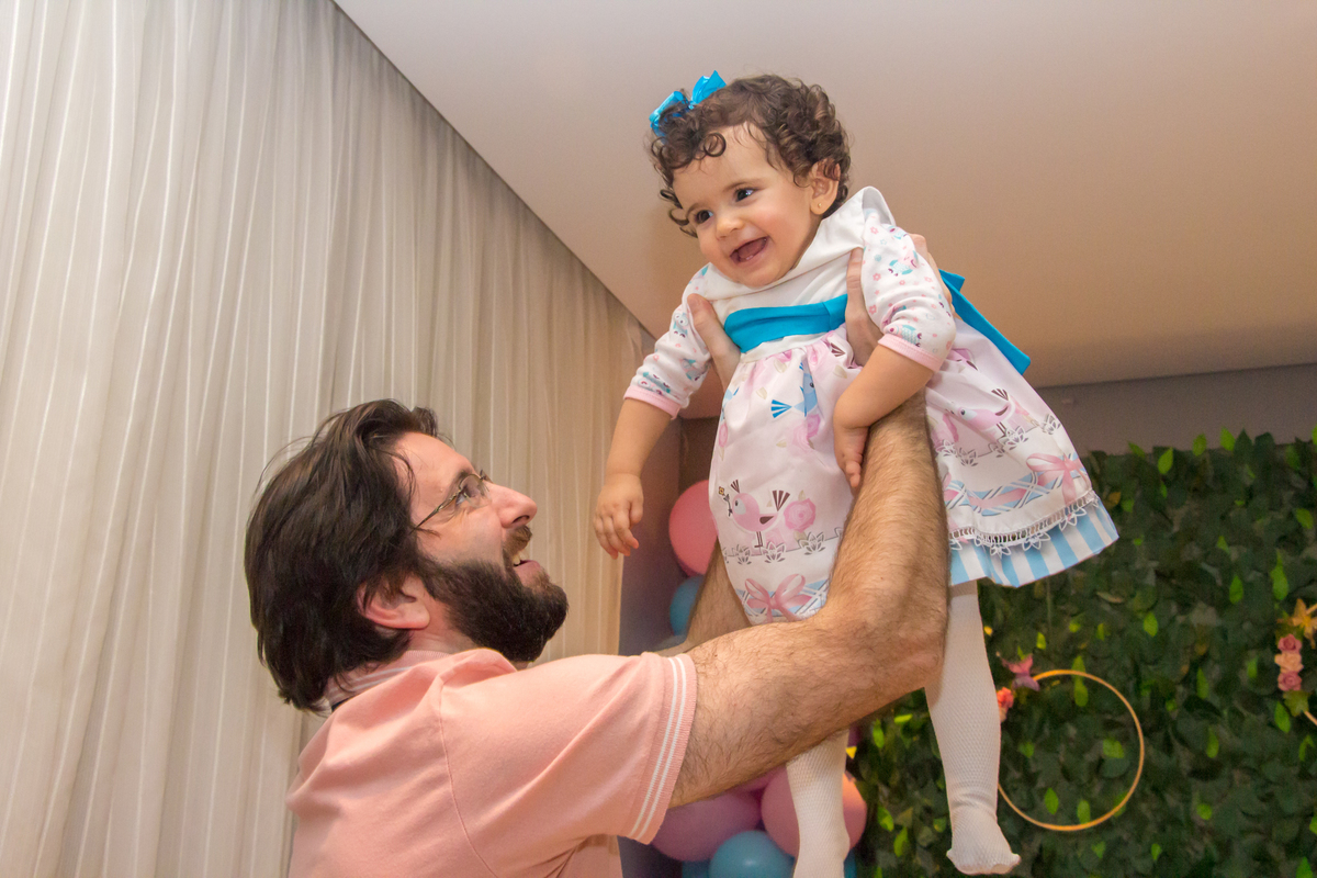 MENINA brincando com o PAI de vestido com LAÇO AZUL em festa tema JARDIM ENCANTADO nas cores VERDE e CORES PASTÉIS no click da FOTÓGRAFA de FESTA INFANTIL em SÃO PAULO, SP em uma imagem colorida