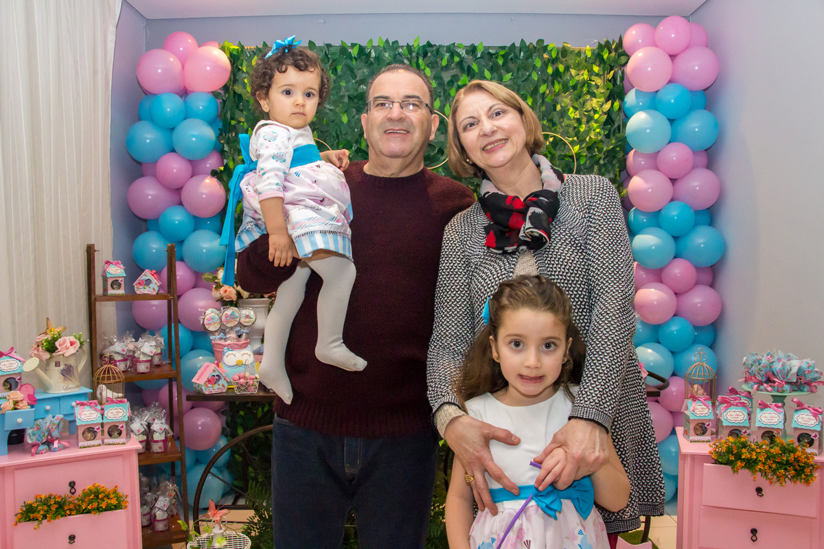MENINA no colo dos AVÓS com IRMÃ de vestido com LAÇO AZUL em festa tema JARDIM ENCANTADO nas cores VERDE e CORES PASTÉIS no click da FOTÓGRAFA de FESTA INFANTIL em SÃO PAULO, SP em uma imagem colorida