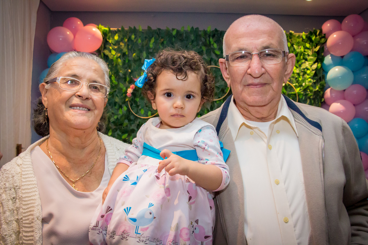 MENINA no colo dos AVÓS de vestido com LAÇO AZUL em festa tema JARDIM ENCANTADO nas cores VERDE e CORES PASTÉIS no click da FOTÓGRAFA de FESTA INFANTIL em SÃO PAULO, SP em uma imagem colorida