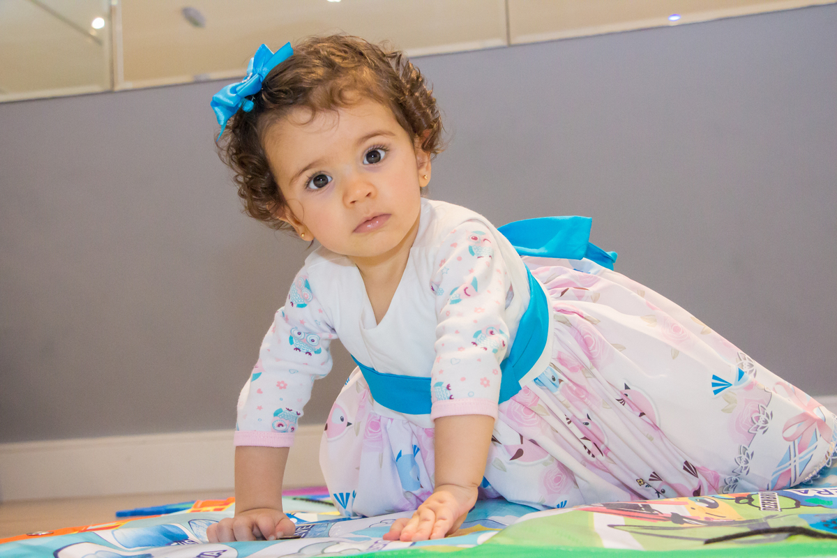 MENINA engatinhando de vestido com LAÇO AZUL em festa tema JARDIM ENCANTADO nas cores VERDE e CORES PASTÉIS no click da FOTÓGRAFA de FESTA INFANTIL em SÃO PAULO, SP em uma imagem colorida