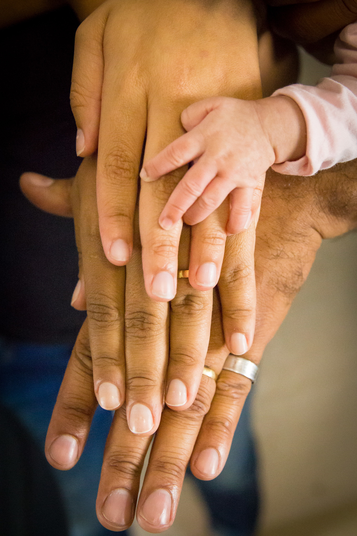 FAMÍLIA segurando BEBÊ dormindo RECÉM NASCIDA detalhes nas MÃOS no click da FOTÓGRAFA de FAMÍLIA e NEWBORN em OSASCO, SP em uma imagem colorida