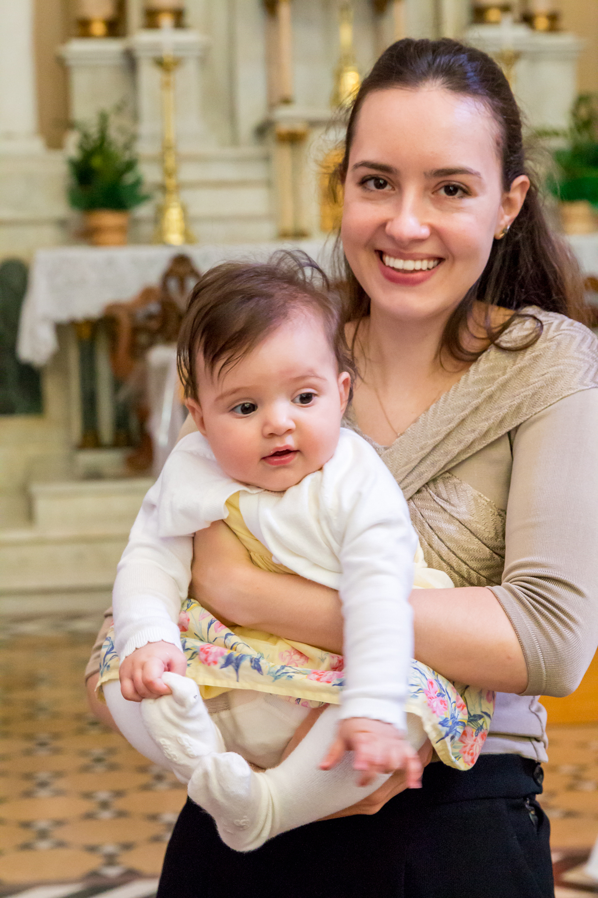 Irmã do NOIVO segurando BEBÊ na IGREJA em CASAMENTO no click da FOTÓGRAFA de CASAMENTO em SÃO PAULO, SP em uma imagem colorida