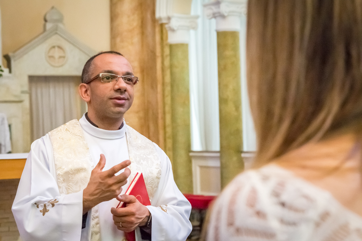 PADRE falando aos NOIVOS na IGREJA em CASAMENTO no click da FOTÓGRAFA de CASAMENTO em SÃO PAULO, SP em uma imagem colorida