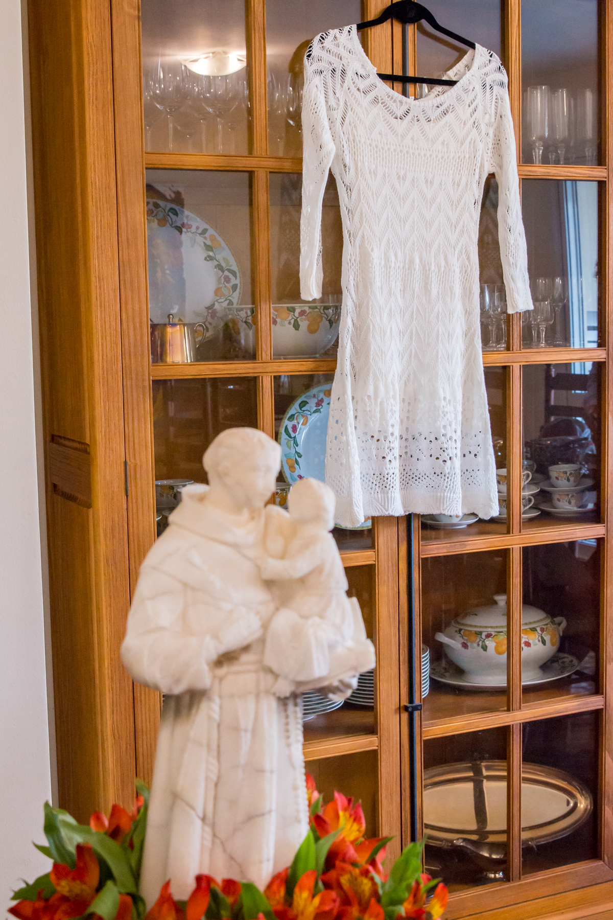 VESTIDO DE NOIVA em detalhe com imagem de SANTO ANTÔNIO na casa dos NOIVOS no click da FOTÓGRAFA de CASAMENTO em SÃO PAULO, SP em uma imagem colorida