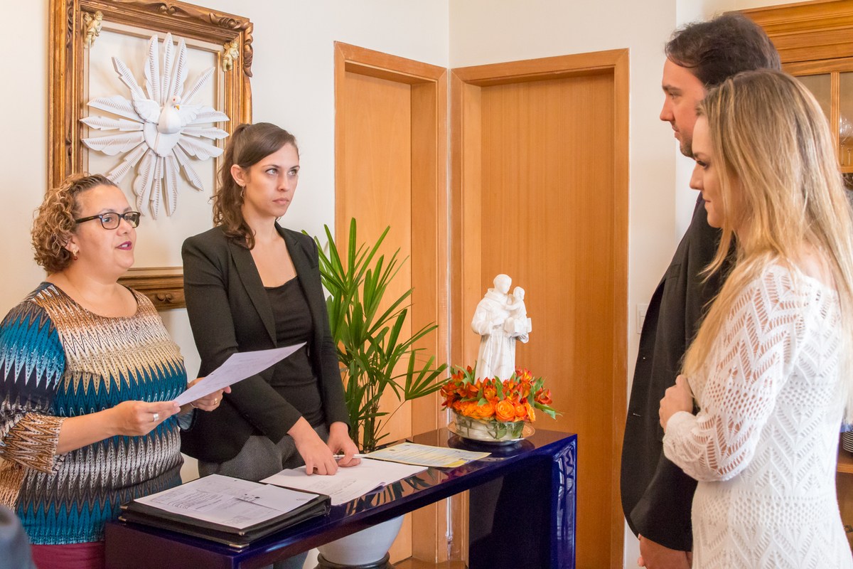 NOIVOS em CASAMENTO CIVIL com imagem de SANTO ANTÔNIO na mesa na casa dos NOIVOS no click da FOTÓGRAFA de CASAMENTO em SÃO PAULO, SP em uma imagem colorida