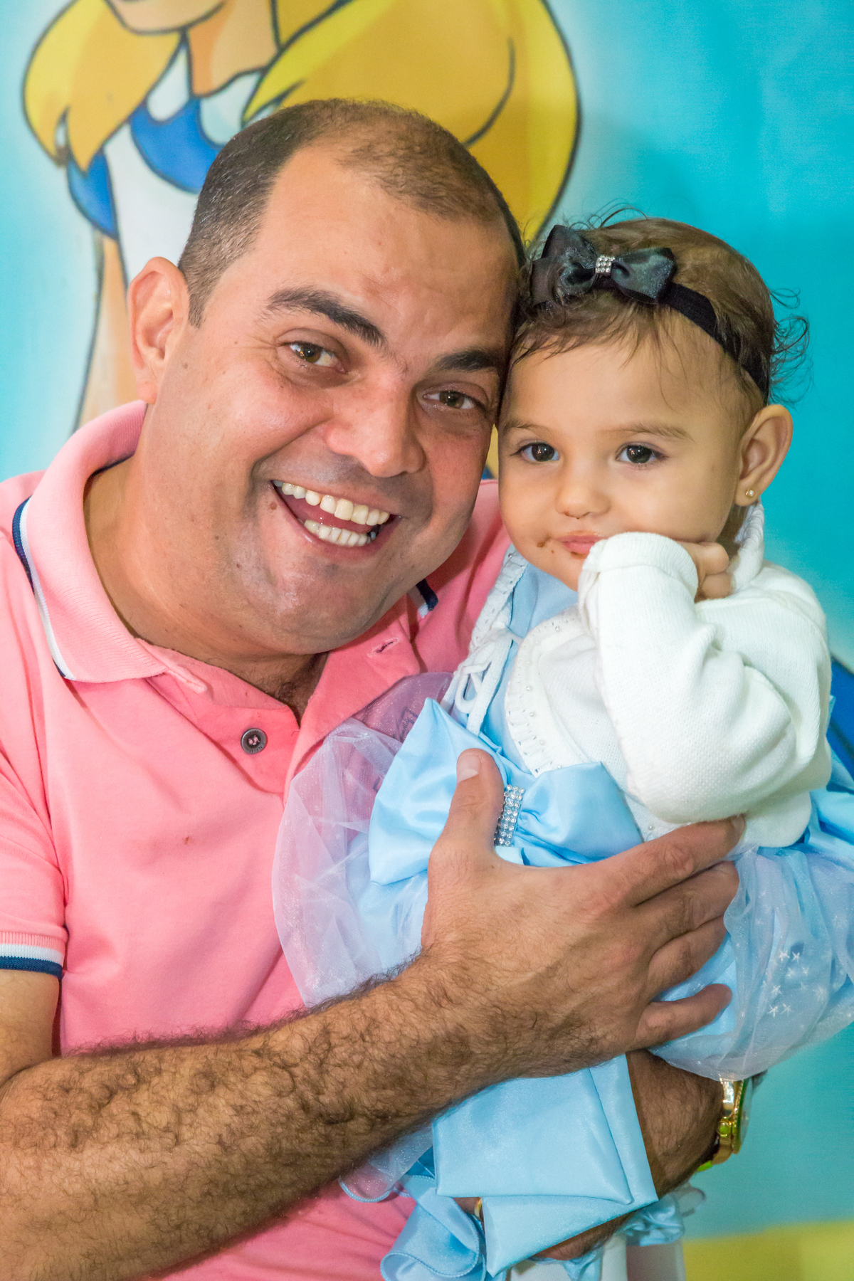 MENINA de VESTIDO AZUL no COLO do PAI em frente a decoração tema ALICE NO PÁIS DAS MARAVILHAS no click do FOTÓGRAFO de FESTA INFANTIL em SÃO PAULO, SP em uma imagem colorida