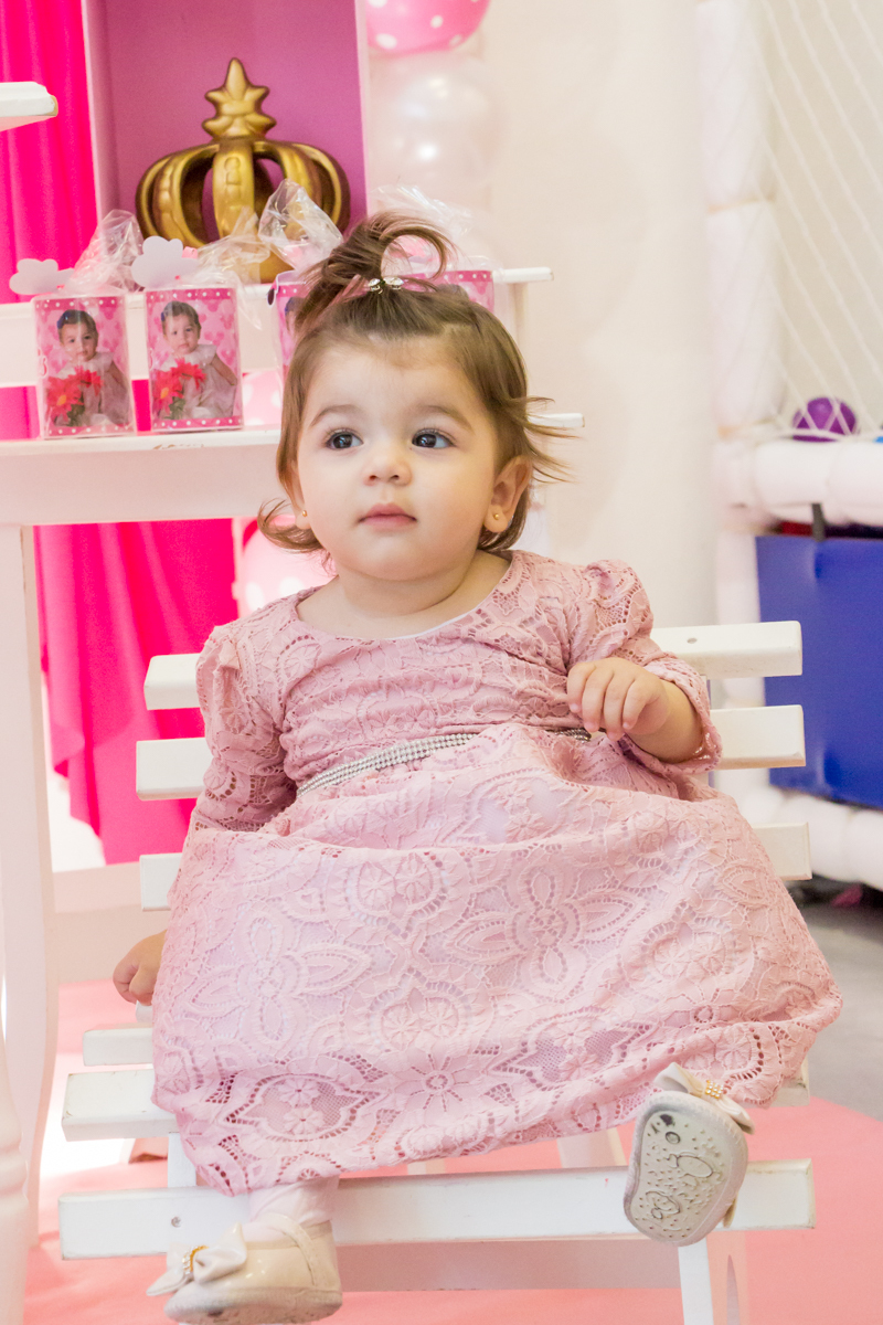 MENINA sentada de VESTIDO rosa em frente a decoração tema MINNIE nas cores ROSA e BRANCO no click do FOTÓGRAFO de FESTA INFANTIL em SÃO PAULO, SP em uma imagem colorida