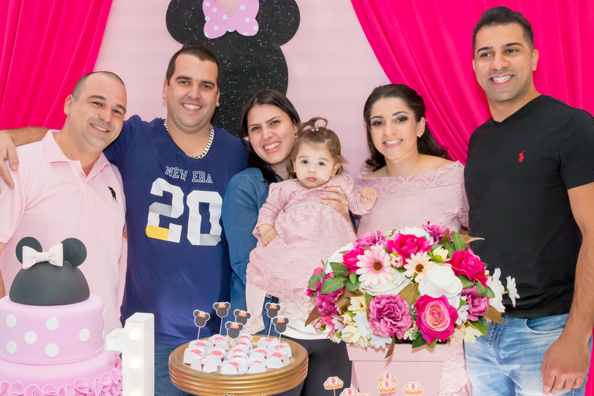 MENINA com os TIOS de VESTIDO rosa em frente a decoração tema MINNIE nas cores ROSA e BRANCO no click do FOTÓGRAFO de FESTA INFANTIL em SÃO PAULO, SP em uma imagem colorida