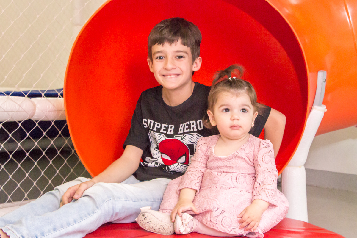 MENINA sentada de VESTIDO rosa BRINCANDO com o IRMÃO no click do FOTÓGRAFO de FESTA INFANTIL em SÃO PAULO, SP em uma imagem colorida