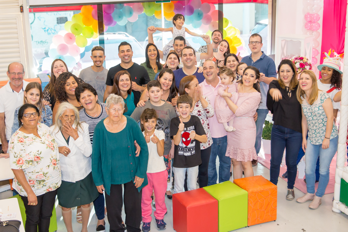 MENINA com a FAMÍLIA em frente a decoração tema MINNIE nas cores ROSA e BRANCO no click do FOTÓGRAFO de FESTA INFANTIL em SÃO PAULO, SP em uma imagem colorida