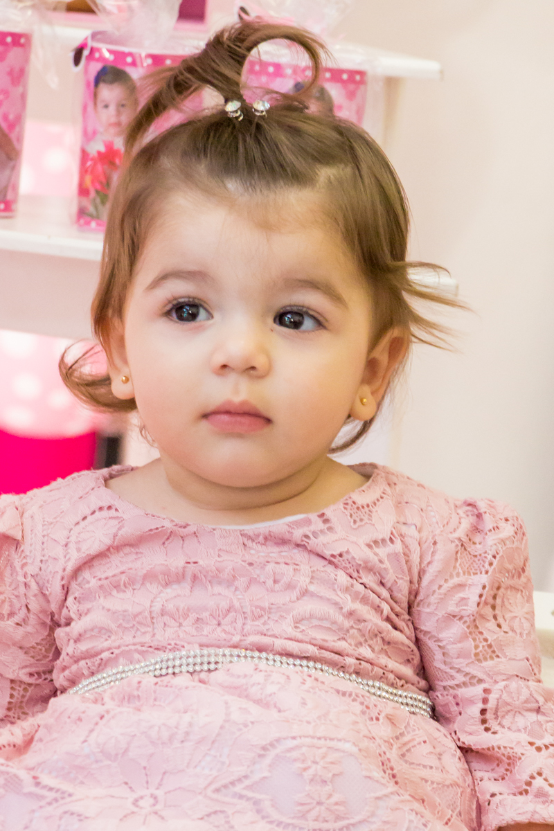 MENINA sentada de VESTIDO rosa em frente a decoração tema MINNIE nas cores ROSA e BRANCO no click do FOTÓGRAFO de FESTA INFANTIL em SÃO PAULO, SP em uma imagem colorida