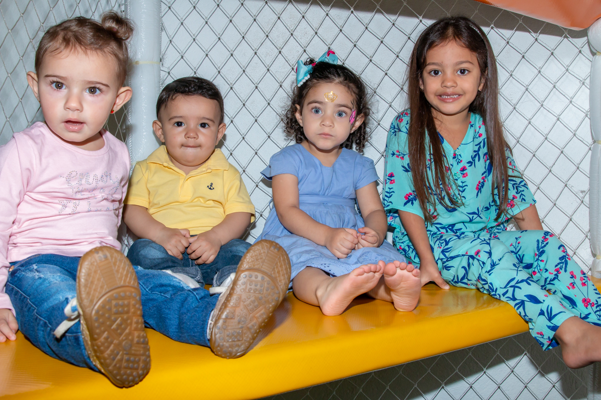 MENINA sorrindo de VESTIDO AZUL brincando com os PRIMOS em BRINQUEDÃO no click do FOTÓGRAFO de FESTA INFANTIL em SÃO PAULO, SP em uma imagem colorida