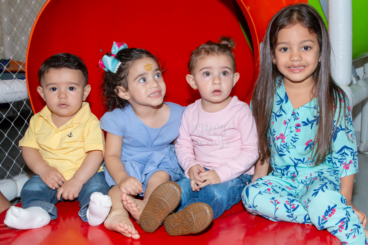 MENINA sorrindo de VESTIDO AZUL brincando com os PRIMOS em BRINQUEDÃO no click do FOTÓGRAFO de FESTA INFANTIL em SÃO PAULO, SP em uma imagem colorida