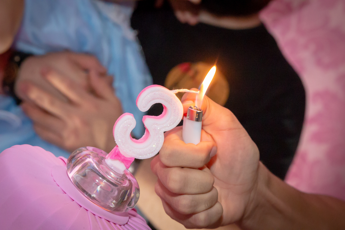 VELA sendo ACESA em decoração tema PRINCESAS nas cores ROSA, DOURADO e LILÁS no click do FOTÓGRAFO de FESTA INFANTIL em SÃO PAULO, SP em uma imagem colorida