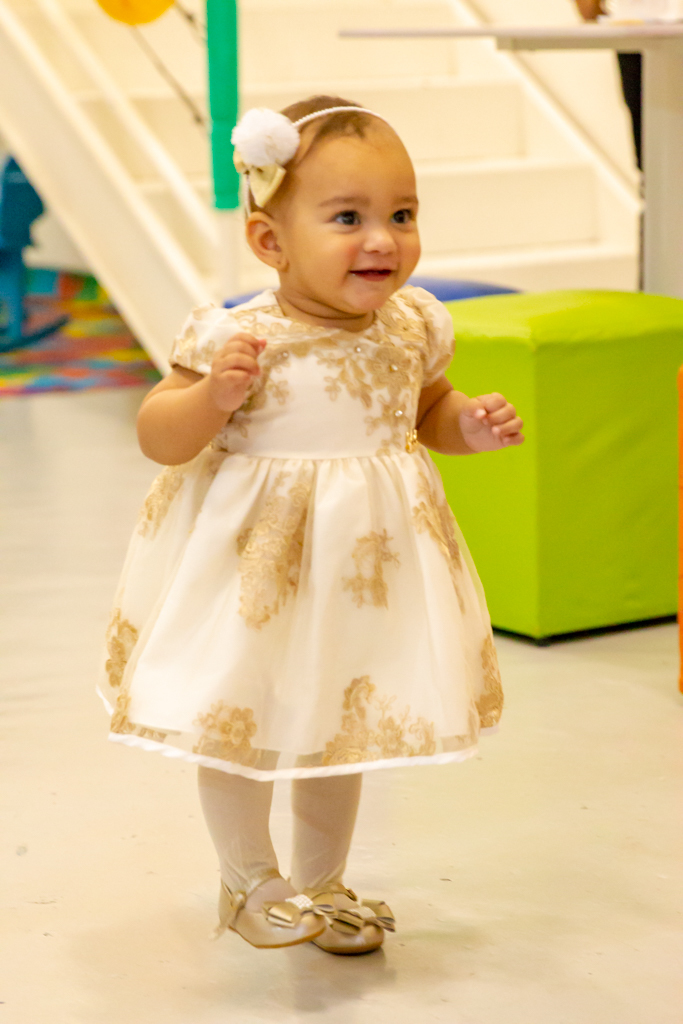 MENINA de VESTIDO DOURADO em frente a decoração tema a BELA e a FERA no click do FOTÓGRAFO de FESTA INFANTIL em SÃO PAULO, SP em uma imagem colorida