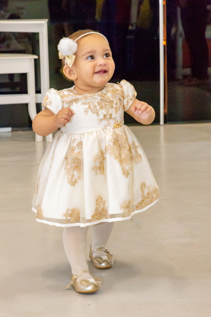 MENINA de VESTIDO DOURADO em frente a decoração tema a BELA e a FERA no click do FOTÓGRAFO de FESTA INFANTIL em SÃO PAULO, SP em uma imagem colorida