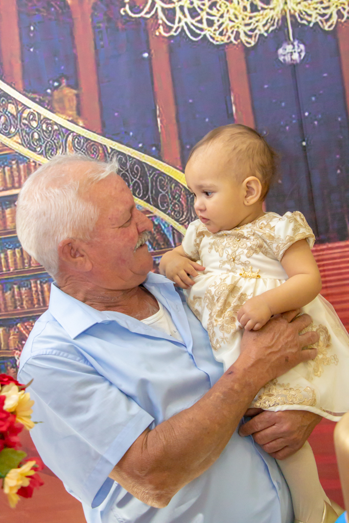 MENINA com seu AVÔ em frente a decoração tema a BELA e a FERA no click do FOTÓGRAFO de FESTA INFANTIL em SÃO PAULO, SP em uma imagem colorida