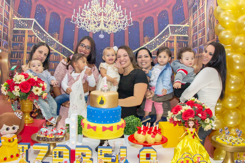 MENINA com seus PAIS em frente a decoração tema a BELA e a FERA no click do FOTÓGRAFO de FESTA INFANTIL em SÃO PAULO, SP em uma imagem colorida