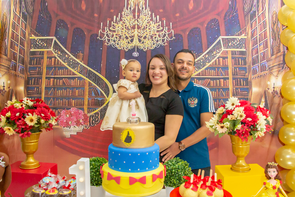 MENINA com seus PAIS em frente a decoração tema a BELA e a FERA no click do FOTÓGRAFO de FESTA INFANTIL em SÃO PAULO, SP em uma imagem colorida
