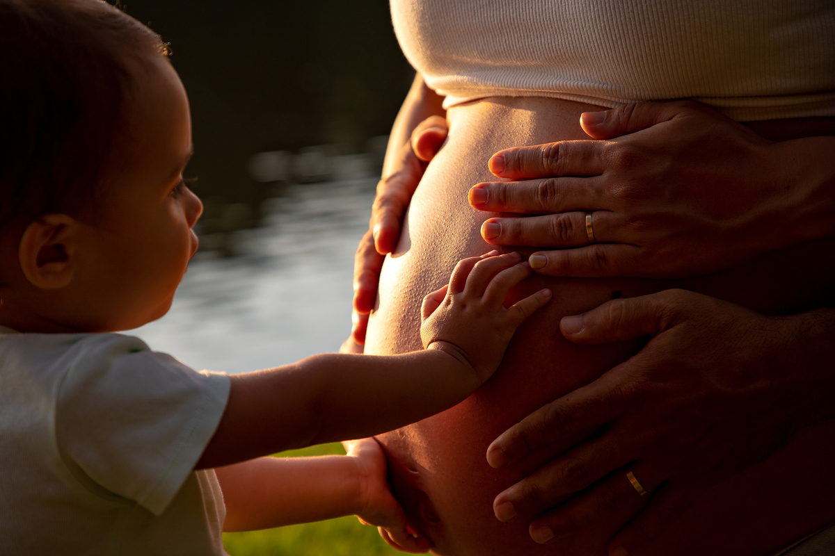 Mulher GRÁVIDA com a BARRIGA de fora, posando em ENSAIO GESTANTE com a FILHA em um SÍTIO, em click do FOTÓGRAFO de GESTANTE.