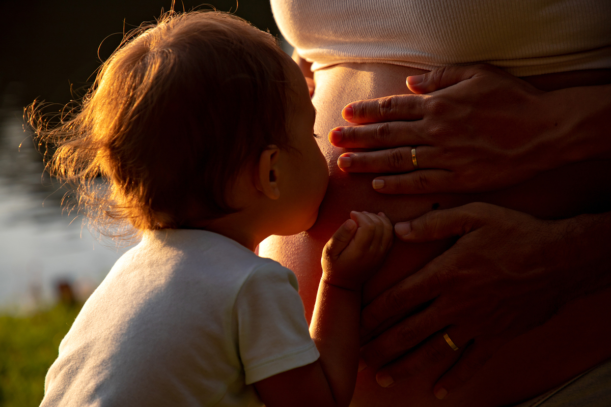 Mulher GRÁVIDA com a BARRIGA de fora, posando em ENSAIO GESTANTE com a FILHA em um SÍTIO, em click do FOTÓGRAFO de GESTANTE.