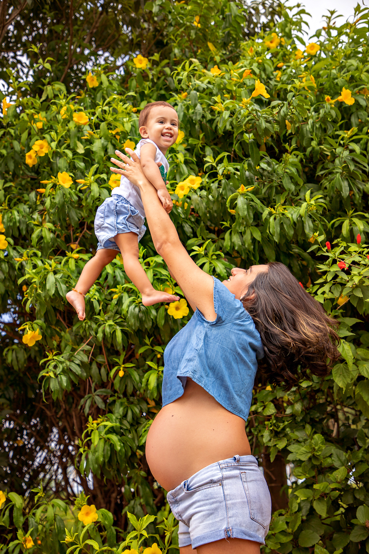 Mulher GRÁVIDA com a BARRIGA de fora, posando em ENSAIO GESTANTE com a FILHA em um SÍTIO, em click do FOTÓGRAFO de GESTANTE.