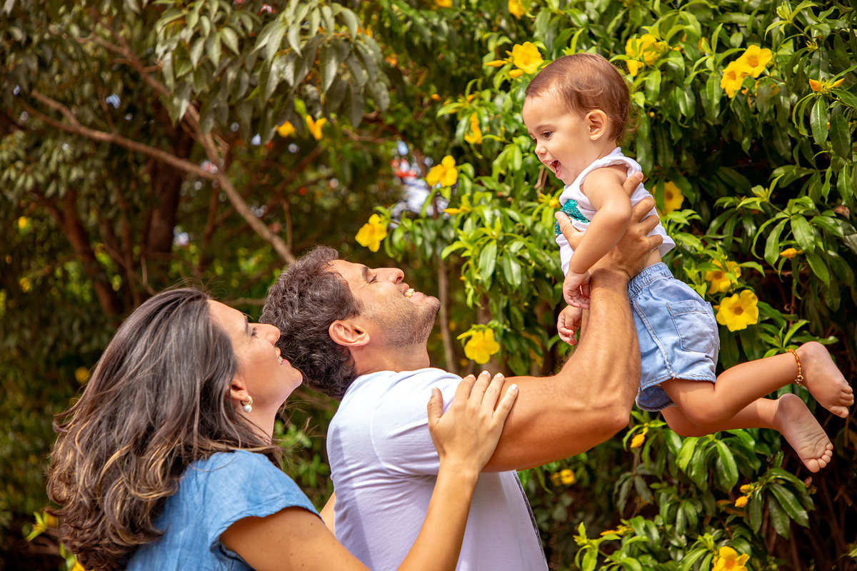 Mulher GRÁVIDA com a BARRIGA de fora, posando com o MARIDO e a FILHA em ENSAIO GESTANTE em um SÍTIO, em click do FOTÓGRAFO de GESTANTE.
