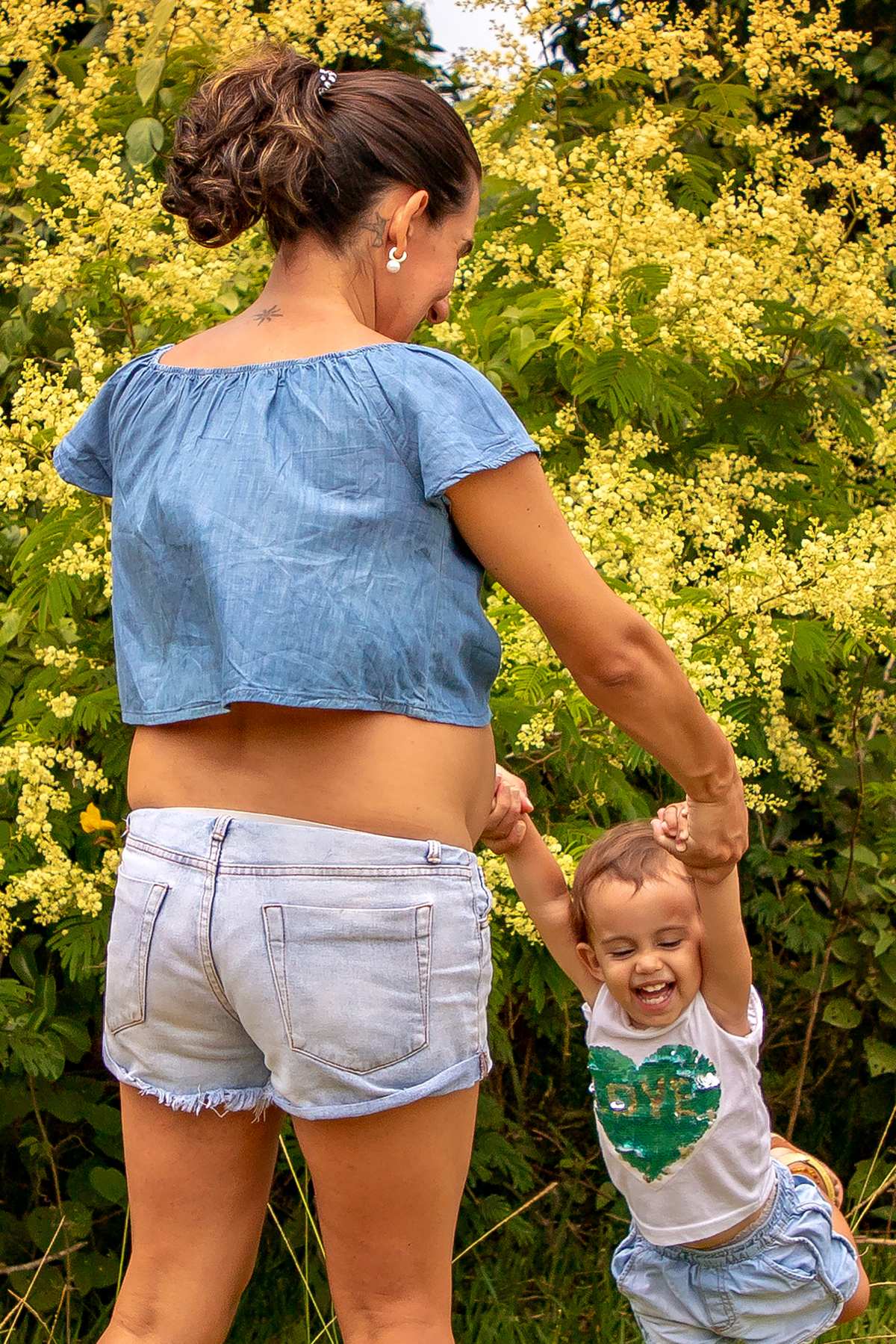 Mulher GRÁVIDA com a BARRIGA de fora, posando em ENSAIO GESTANTE com a FILHA em um SÍTIO, em click do FOTÓGRAFO de GESTANTE.