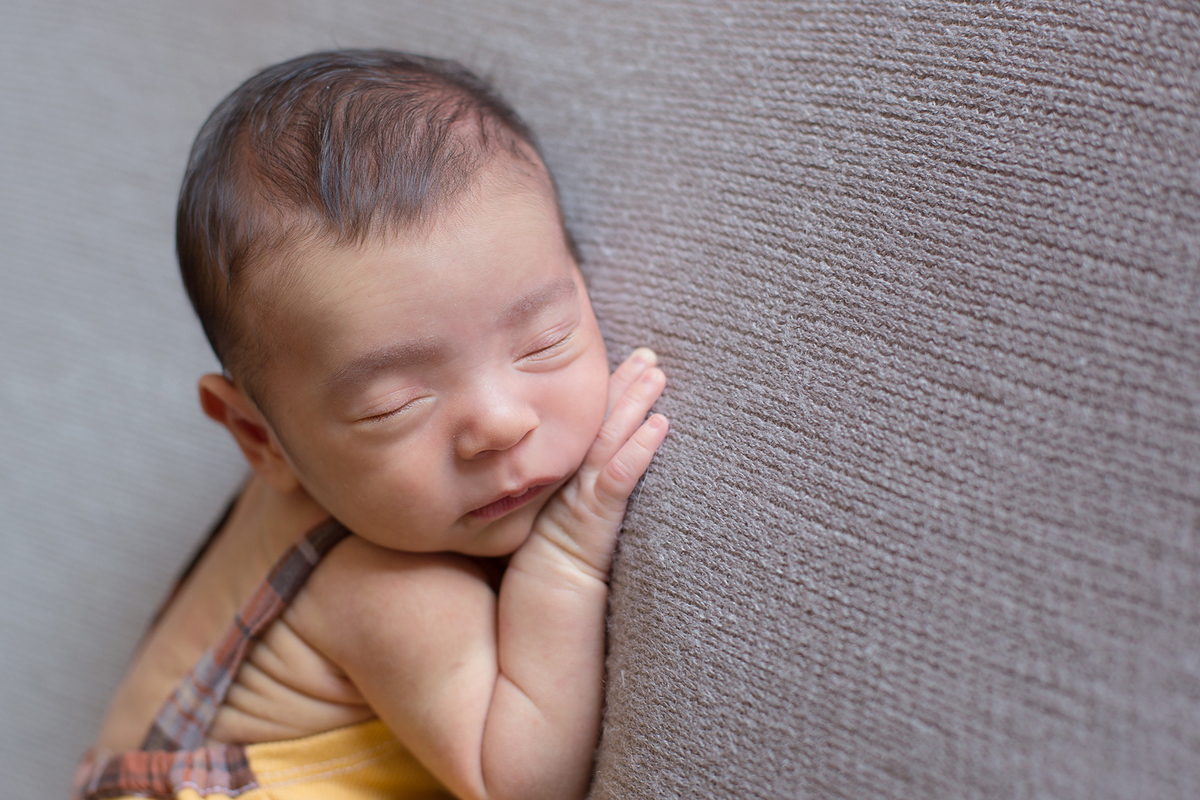 Newborn Gabriel filho mais novo da Thali Freitas ensaio a domicilio ensaio em casa Zona Sul de São Paulo pose da bundinha em manta cinza e composição com amarelo e mostarda