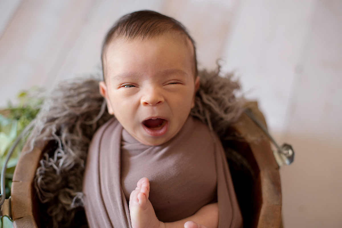 Bocejo de bebe recem nascido ensaio newborn em casa ensaio newborn a domicilio bebê enroladinho pés e pernas para fora composição marrom e verde