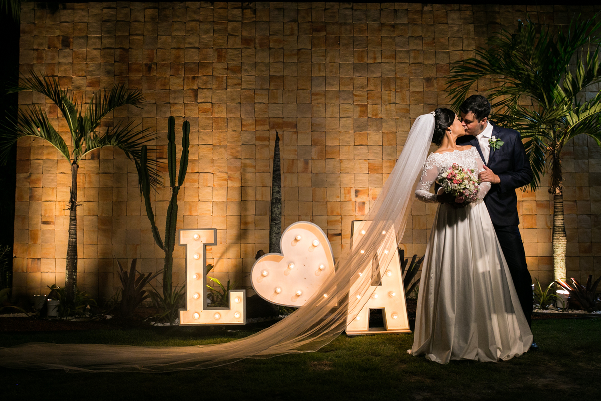 os noivos se beijando com um destaque no lindo vestido de casamento 