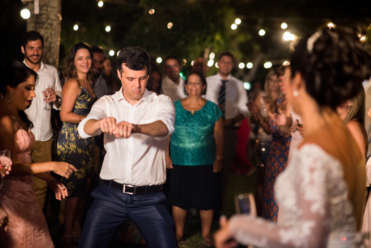 a noiva vendo o noivo dançando na sua festa de casamento 