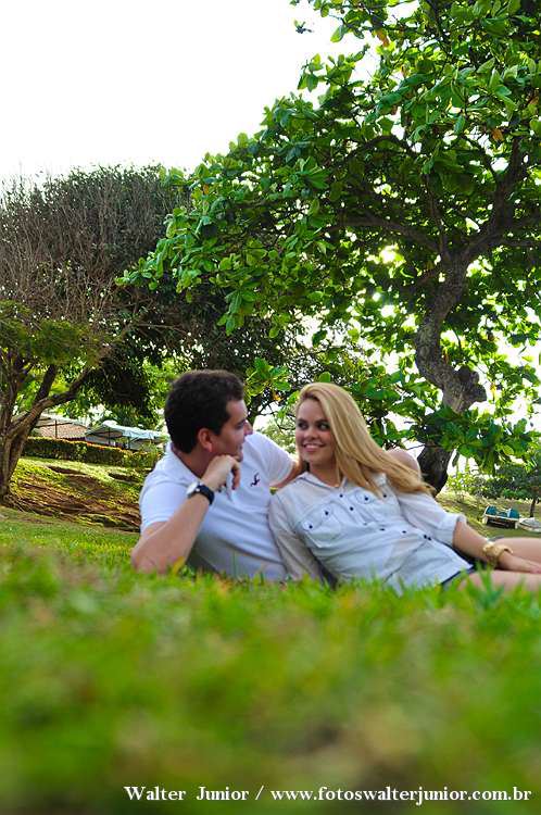 noivos deitados na grama fazendo seu ensaio fotografico