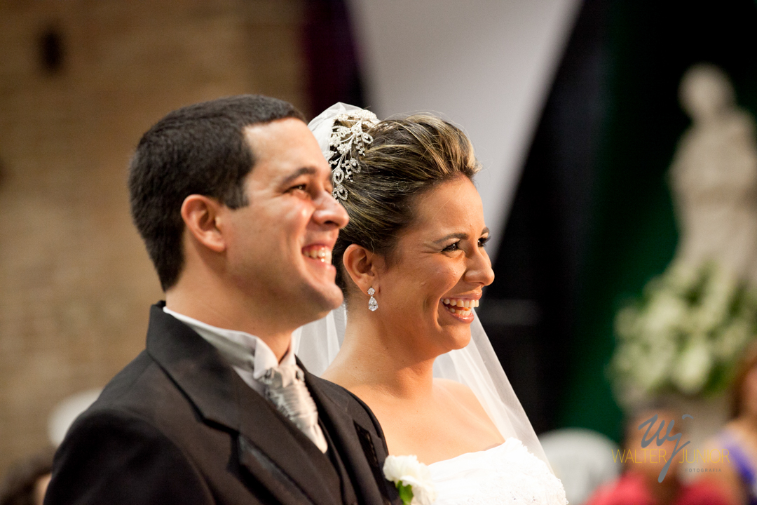noivos sorrindo com o sermão do padre 