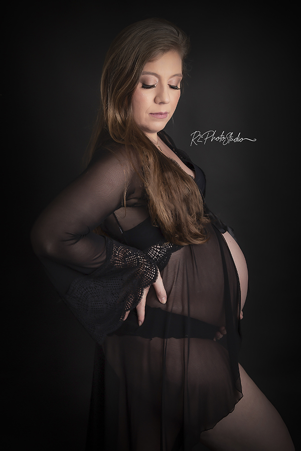 Foto de gestante com robi preto em fundo preto