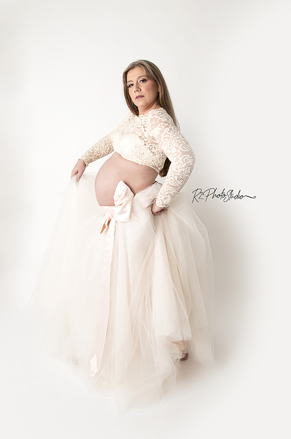 Foto de Gestante loira de croppet e saia rodada creme em fundo branco