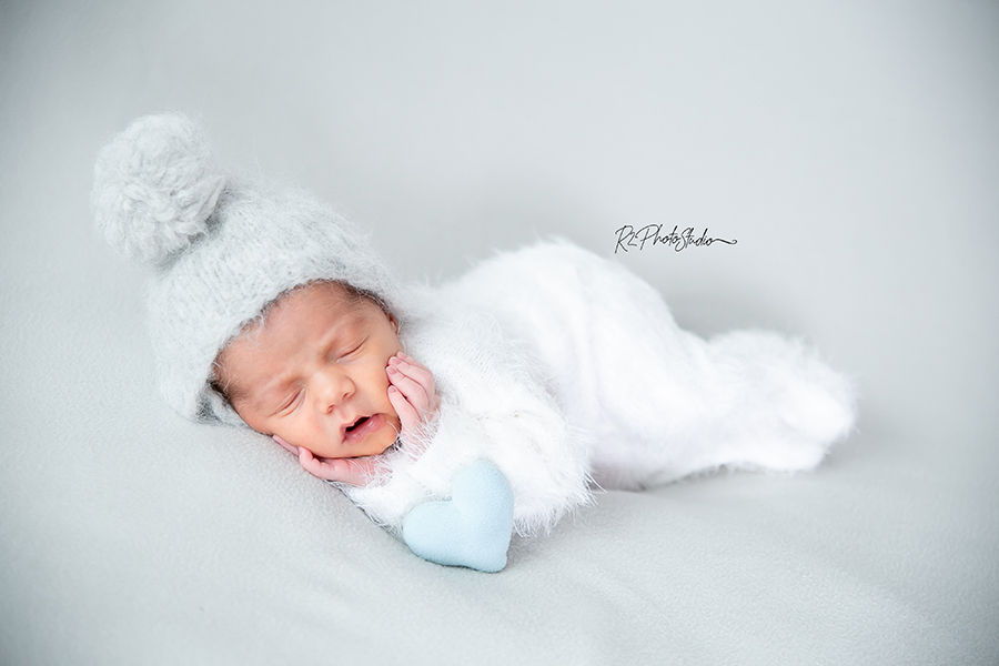 foto de bebe na pose de ladinho com as mãos na bochecha