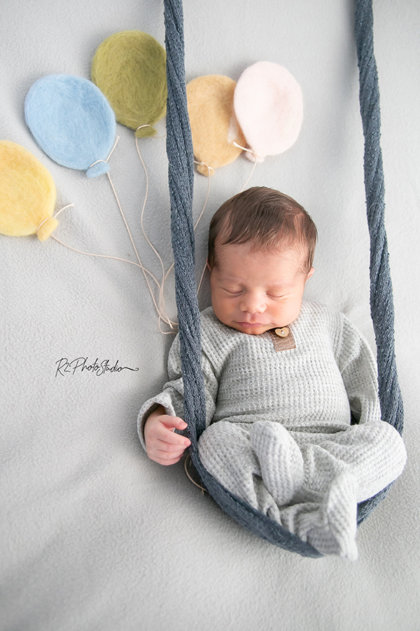 foto de bebe no balanço segurando balões